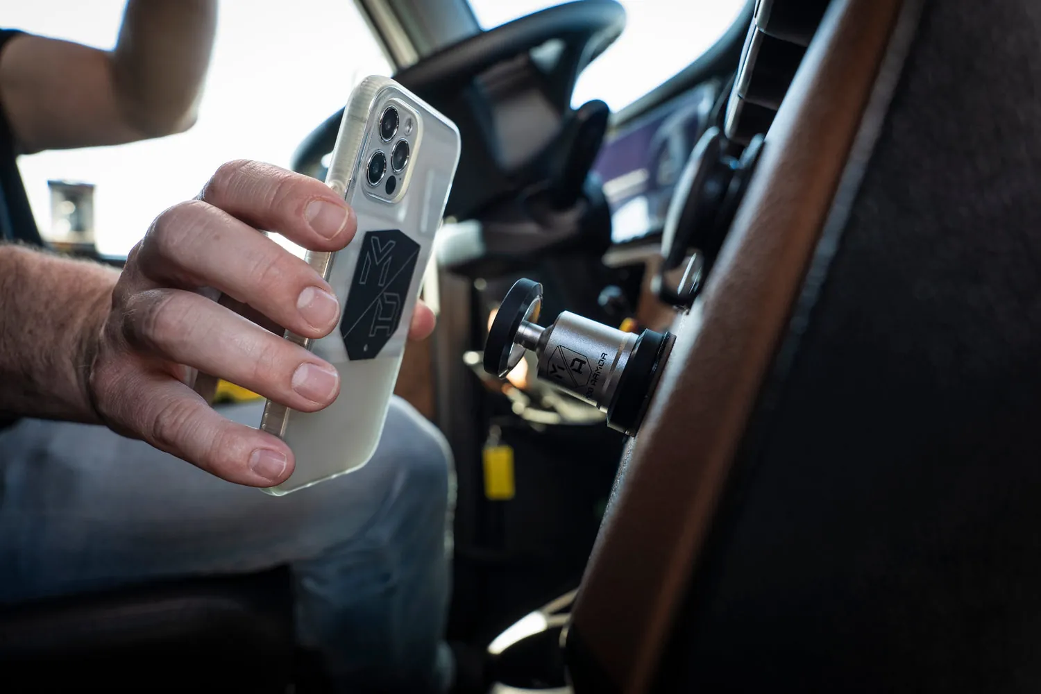iPhone held by a magnetic car vent mount in daylight