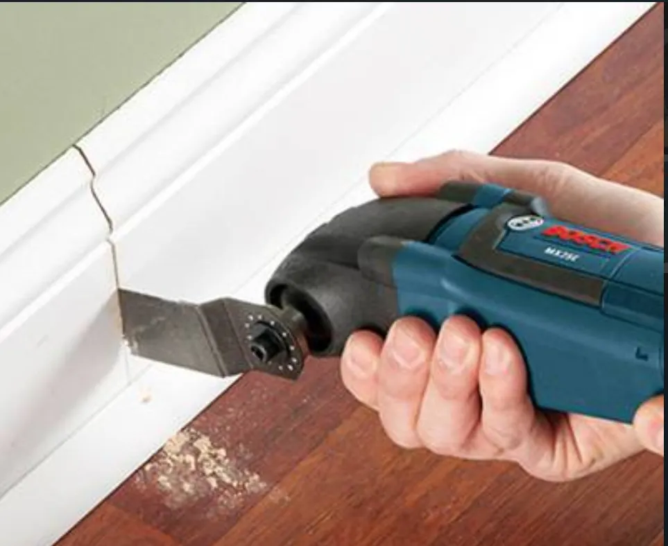 Small multitool beside full-size screwdriver and pliers on workbench
